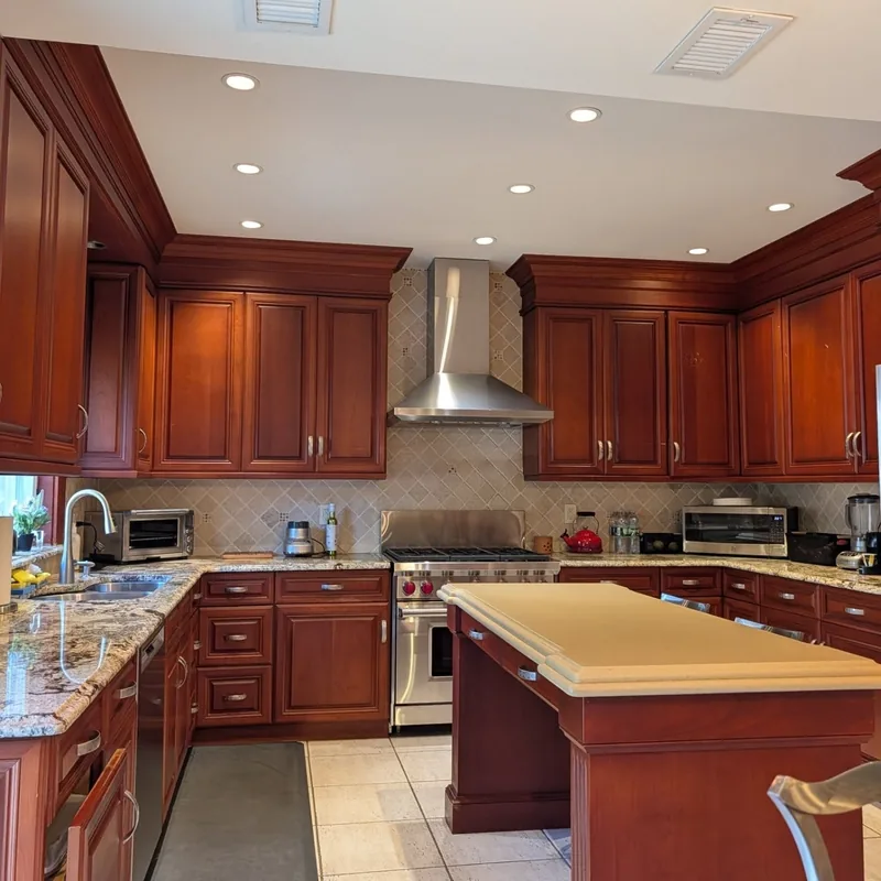 A detailed kitchen with polished wood cabinets and stainless appliances.
