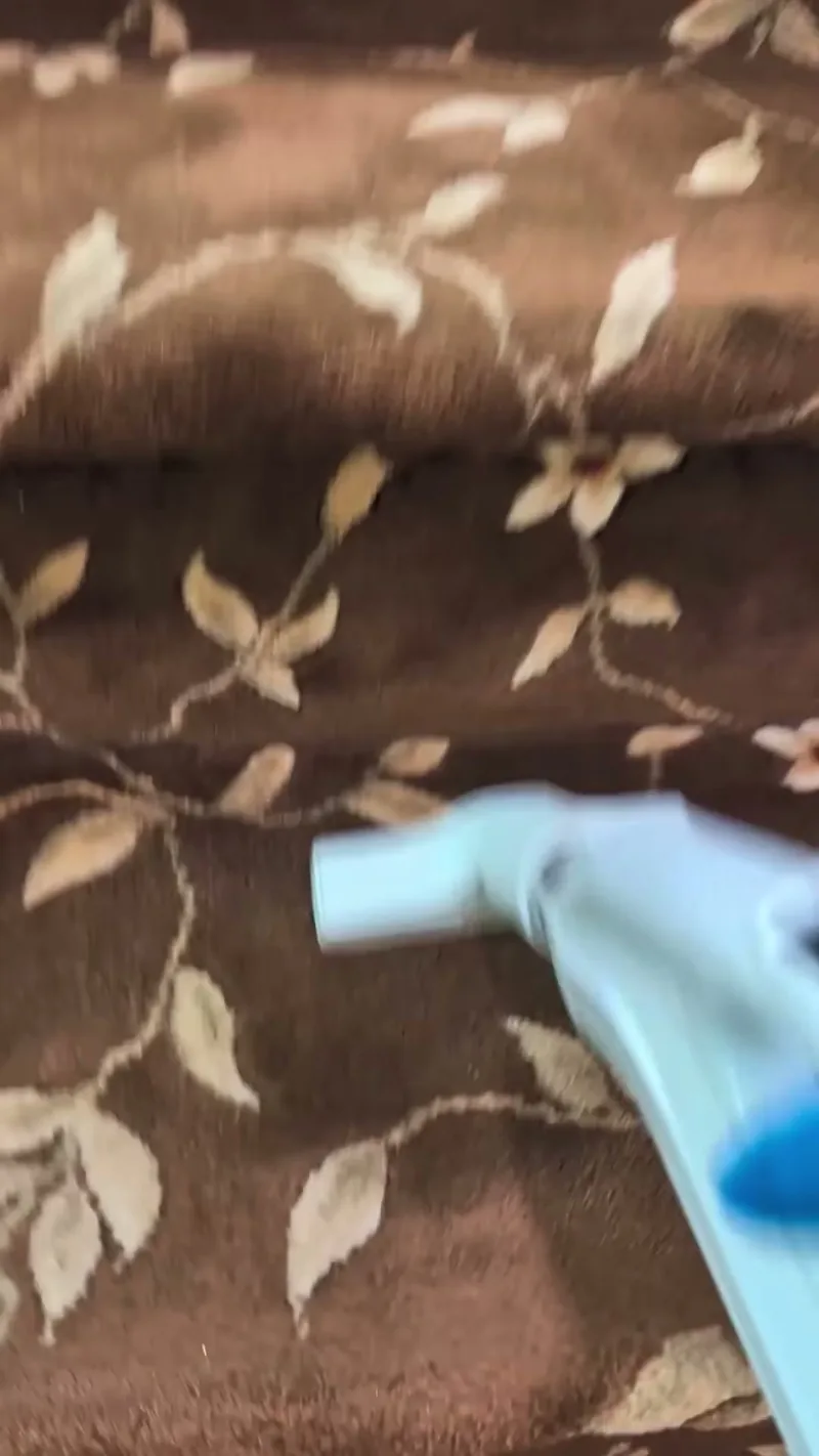 A patterned stair runner being vacuumed.